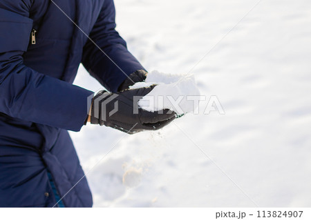 pile of snow in hands after heavy snowfall. man in gloves and winter clothes takes snow in his hands. leisure activities, snowball fight game pile of snow in hands after heavy snowfall. man in gloves and winter clothes takes snow in his hands. leisure activities, snowball fight game 113824907