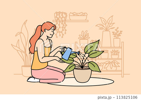 Woman florist grows houseplants to decorate own apartment, waters flower while sitting on floor 113825106