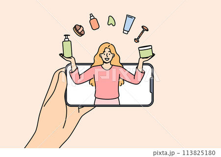 Woman beauty blogger juggles with cosmetics, looking out from phone, giving tips on applying makeup 113825180