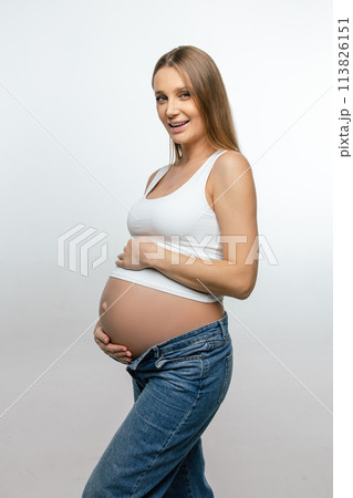 Smiling pregnant woman in jeans and white tshirt 113826151