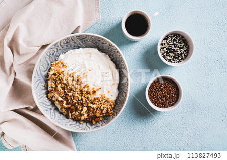 Bowl with yogurt, muesli and nuts for a healthy breakfast on the table top view 113827493