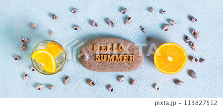 Concept hello summer text on stone, cocktail, orange and seashells on blue top view web banner 113827512