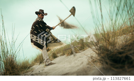 Man digs a grave in the desert 113827661