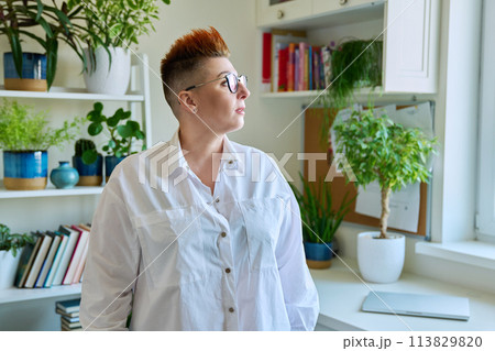 Profile portrait of serious middle-aged woman in glasses with red haircut Profile portrait of serious middle-aged woman in glasses with red haircut 113829820