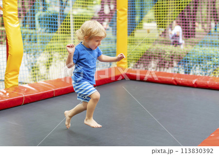 Toddler Jumping on Outdoor Trampoline Toddler Jumping on Outdoor Trampoline 113830392