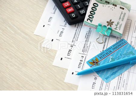 Annual Individual Income Tax Return forms with pen and indonesian rupiah bills. Original name is Surat Pemberitahuan Pajak or SPT Tahunan Annual Individual Income Tax Return forms with pen and indonesian rupiah bills. Original name is Surat Pemberitahuan Pajak or SPT Tahunan 113831654