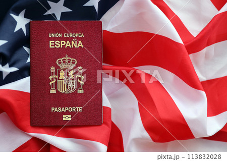 Red Spanish passport of European Union on United States national flag background close up. Tourism and diplomacy concept Red Spanish passport of European Union on United States national flag background close up. Tourism and diplomacy concept 113832028