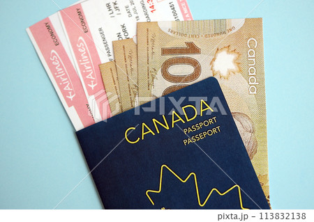 Canadian passport with money and airline tickets on blue background close up. Tourism and travel concept 113832138