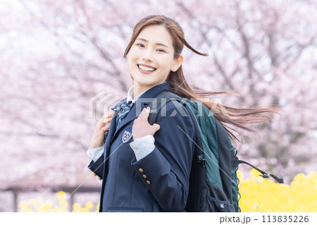 満開の桜の中、新学期を迎え登校する女子高生 113835226