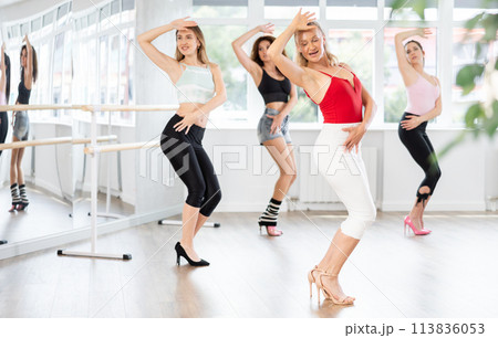 Female instructor performing graceful sass dance movements during group class 113836053