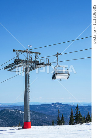 Chairlift in mountains during sunny winter day. Chairlift in mountains during sunny winter day. 113836685