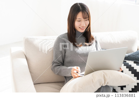 部屋でラップトップコンピューターを見る女性 113836881