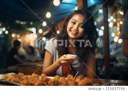 Young Asian woman enjoying fries street food at night market Young Asian woman enjoying fries street food at night market 113837554