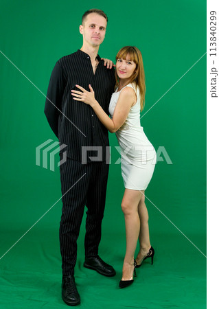 Young attractive business people in formal, black and white clothes. On a green background. High quality photo Young attractive business people in formal, black and white clothes. On a green background. High quality photo 113840299