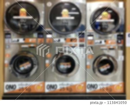 blurred images of clothes dryer and washing machine in laundry shop interior for industry, shop, reatail, service blurred images of clothes dryer and washing machine in laundry shop interior for industry, shop, reatail, service 113841050