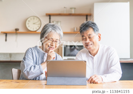 タブレットを使ってビデオ通話・テレビ電話する笑顔のシニア・高齢者夫婦 113841155