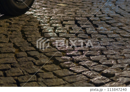 Cobbled street for walking and driving in the evening with different color highlights and effects Cobbled street for walking and driving in the evening with different color highlights and effects 113847240