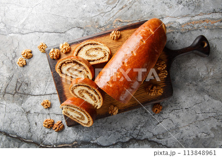 Eastern European Christmas and Easter nut roll made with ground walnuts closeup on the wooden board. Horizontal top view Eastern European Christmas and Easter nut roll made with ground walnuts closeup on the wooden board. Horizontal top view 113848961