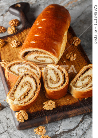 Home baked nut roll, bejgli, traditional sweet bread stuffed with walnut filling closeup on the wooden board. Vertical Home baked nut roll, bejgli, traditional sweet bread stuffed with walnut filling closeup on the wooden board. Vertical 113848975