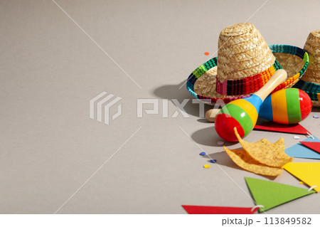 Nachos with sombrero and maracas on a light background Nachos with sombrero and maracas on a light background 113849582
