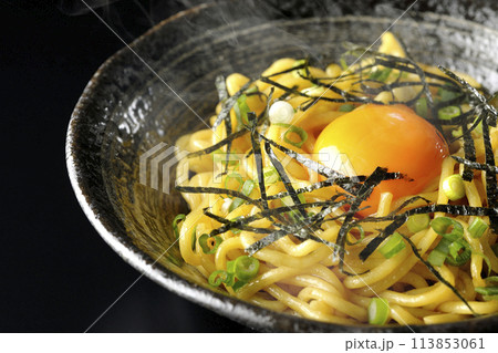 卵黄、刻み海苔、小ねぎが乗った熱々の油そばを黒背景で撮影 113853061