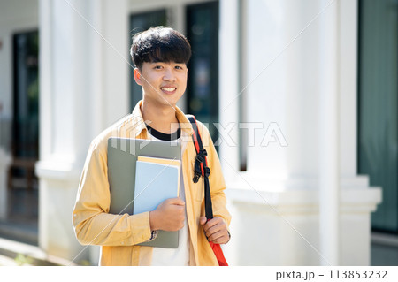 Smiling College Student with Laptop and Books on Campus 113853232