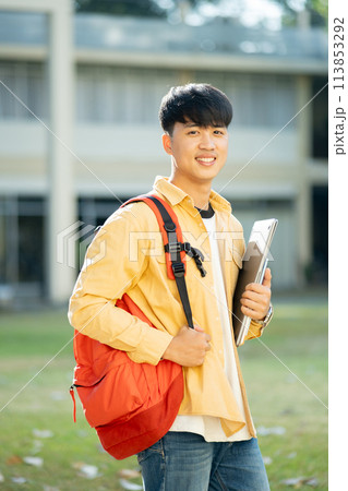 Smiling College Student with Laptop and Books on Campus Smiling College Student with Laptop and Books on Campus 113853292