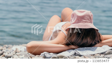 Unrecognizable positive woman in white bikini sunbathing or tanning on seaside beach during summer. happy tourist enjoying sun tan lying on beach chair lounge at luxury resort Unrecognizable positive woman in white bikini sunbathing or tanning on seaside beach during summer. happy tourist enjoying sun tan lying on beach chair lounge at luxury resort 113853477