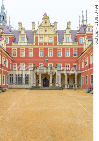 The front view of Chateau Bad Muskau, with visitors on the entrance steps, under a grey, overcast sky. Saxony, Germany 113853794