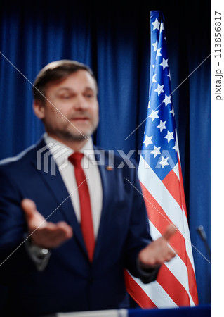 Flag of USA standing behind politician 113856817