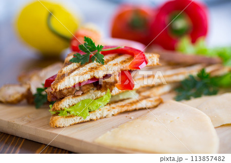 fried toast with chicken, salad, greens on a wooden table fried toast with chicken, salad, greens on a wooden table 113857482