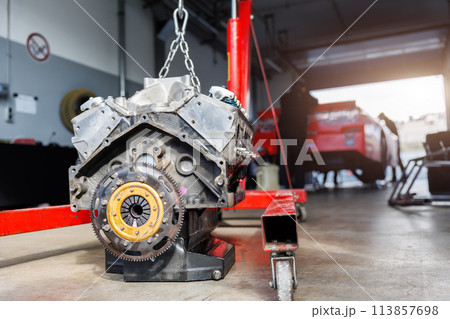 Motorsport pit lane garage box paddock hanged v8 engine suspended crane lift chain hook. Racing garage workshop racecar motor repair. Auto service maintenance sport equipment Motorsport pit lane garage box paddock hanged v8 engine suspended crane lift chain hook. Racing garage workshop racecar motor repair. Auto service maintenance sport equipment 113857698