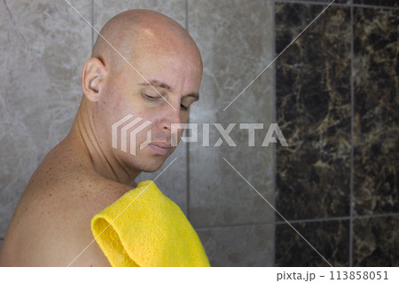Man rubs his shoulder with washcloth in the shower Man rubs his shoulder with washcloth in the shower 113858051