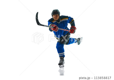 Committed hockey athlete showcases their mastery of attack and pass techniques against white studio background. Committed hockey athlete showcases their mastery of attack and pass techniques against white studio background. 113858817
