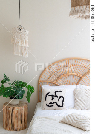 White pillows on wooden weave bed in minimal bedroom interior with green plants. Real photo White pillows on wooden weave bed in minimal bedroom interior with green plants. Real photo 113859061