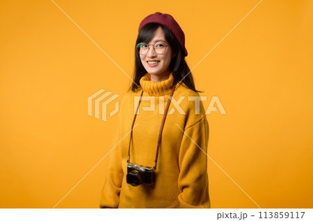 In her stylish studio, a young Asian woman, donning a yellow sweater and red beret, takes a retro portrait using her beloved camera, reminiscent of 20s and 30s nostalgia. In her stylish studio, a young Asian woman, donning a yellow sweater and red beret, takes a retro portrait using her beloved camera, reminiscent of 20s and 30s nostalgia. 113859117