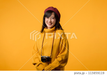 A creative artist, this young Asian woman, dressed in a yellow sweater and red beret, captures moments with her camera, a delightful hobby. A creative artist, this young Asian woman, dressed in a yellow sweater and red beret, captures moments with her camera, a delightful hobby. 113859119