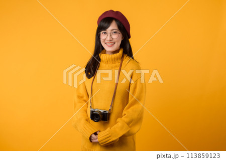 With her camera, a young Asian woman, donning a yellow sweater and red beret, creates beautiful memories in her stylish studio. With her camera, a young Asian woman, donning a yellow sweater and red beret, creates beautiful memories in her stylish studio. 113859123