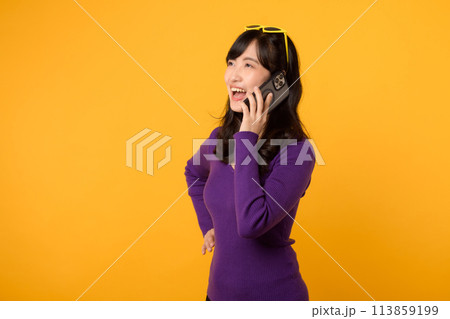Wearing a purple shirt and sunglasses against a vibrant yellow backdrop, lady confidently uses her smartphone for online communication and business networking. Wearing a purple shirt and sunglasses against a vibrant yellow backdrop, lady confidently uses her smartphone for online communication and business networking. 113859199