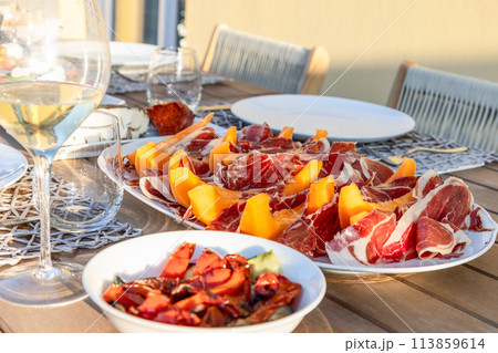 A terrace table in Italy graced with the classic pairing of sweet melon and savory Prosciutto A terrace table in Italy graced with the classic pairing of sweet melon and savory Prosciutto 113859614