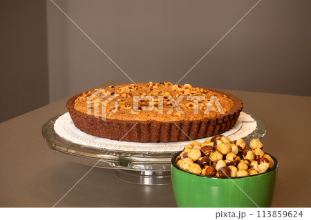Chocolate tart with hazelnut cream and bowl of nuts 113859624