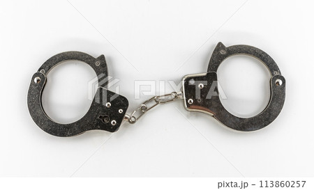 metal handcuffs close-up on a white background, isolates 113860257