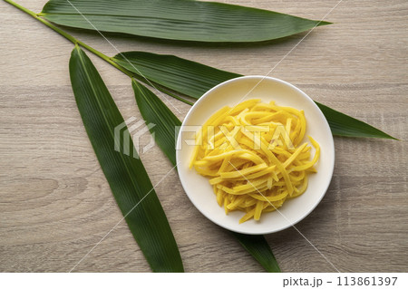 Close up sliced yellow Pickled bamboo shoots on white plate.Top view Close up sliced yellow Pickled bamboo shoots on white plate.Top view 113861397