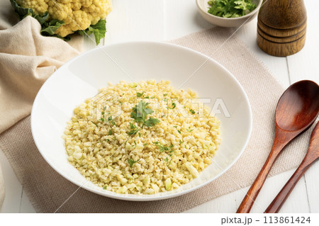 Cauliflower rice in white plate.Low carb diet, healthy eating and low calories food. Cauliflower rice in white plate.Low carb diet, healthy eating and low calories food. 113861424