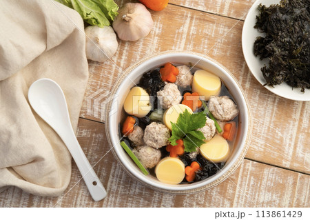 Thai style Clear seaweed soup with glass noodle, Minced Pork,Vegetables and egg tofu in white bowl.(Gaeng Jued ).Top view Thai style Clear seaweed soup with glass noodle, Minced Pork,Vegetables and egg tofu in white bowl.(Gaeng Jued ).Top view 113861429