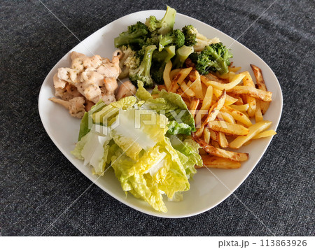 Homemade grilled chicken with french fries, broccoli and green salad, served on a white plate Homemade grilled chicken with french fries, broccoli and green salad, served on a white plate 113863926