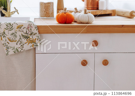 A kitchen counter with a white cabinet and a towel with a floral design A kitchen counter with a white cabinet and a towel with a floral design 113864696