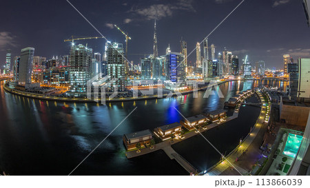 Night city Dubai near canal with bright skyscrapers aerial timelapse 113866039