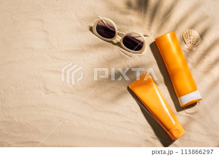 Sunblock lotion bottles on sandy beach Sunblock lotion bottles on sandy beach 113866297
