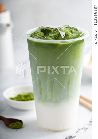 Matcha iced latte in a tall glass with matcha tea over milk 113866387